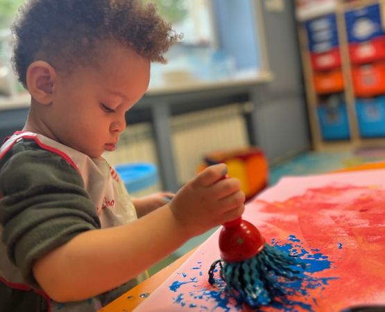 boy painting with blue brush itsw nursery